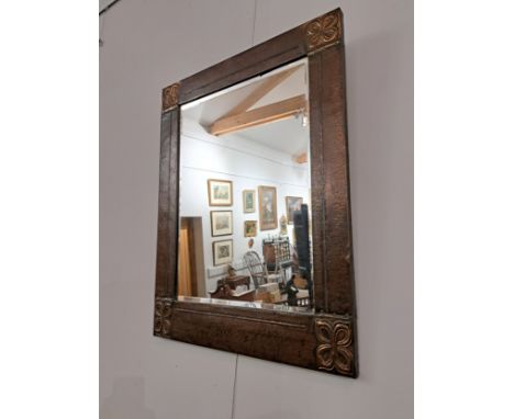 An Arts and Crafts hammered copper wall mirror of rectangular form, Celtic style corners 
