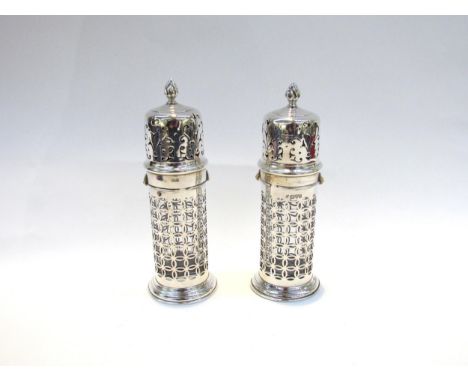A pair of Haseler Bros silver openwork bayonet topped pierced sugar castors with clear glass liners, 17cm approximate height,
