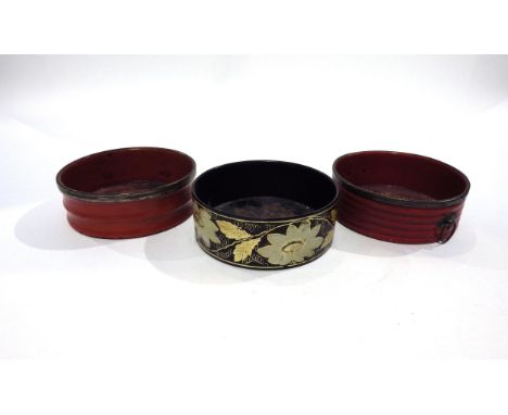 Three Regency papier-mache wine bottle coasters circa 1820, two red one black decorated with flowers, all approximately 12.5c