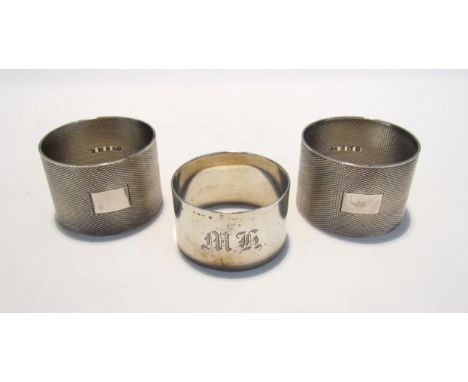 Three silver napkin rings including a pair of engine turned examples, 115g 
