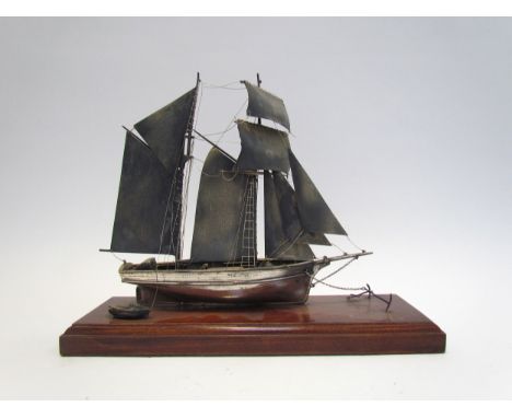 A silver model of a sailing vessel, hallmark indistinct, 22cm tall, on plinth base 