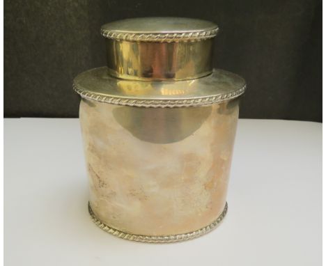 An Atkin Brothers silver tea caddy, gadrooned detail to edges, 12cm tall, Sheffield 1923, 194g, slightly misshapen top 