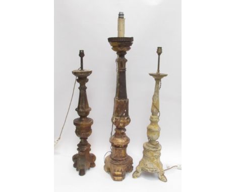 Three 19th Century carved wood lamp bases in a rustic condition, 94cm, 76cm and 73cm tall 