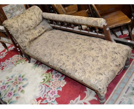 A Victorian mahogany chaise, padded rail to spindled back, scrolling arm, stuffed overseat, turned legs, ceramic casters, c.1