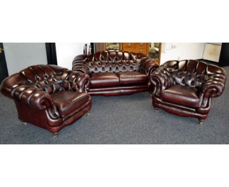 A Thomas Lloyd ox blood leather Chesterfield style three piece suite comprising two seat button back sofa  and two conforming