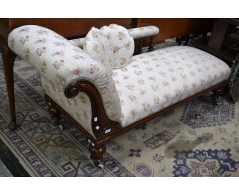 A Victorian mahogany chaise, scrolling arm, padded top rail, spindle back, stuffed overseat, turned legs, ceramic casters.