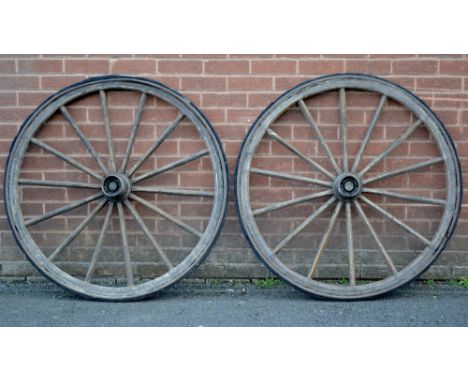 A pair of vintage cart wheels with vulcanized rubber applied to the rim.