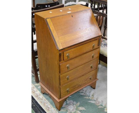 A small golden oak bureau, fall front, four drawers, bracket feet