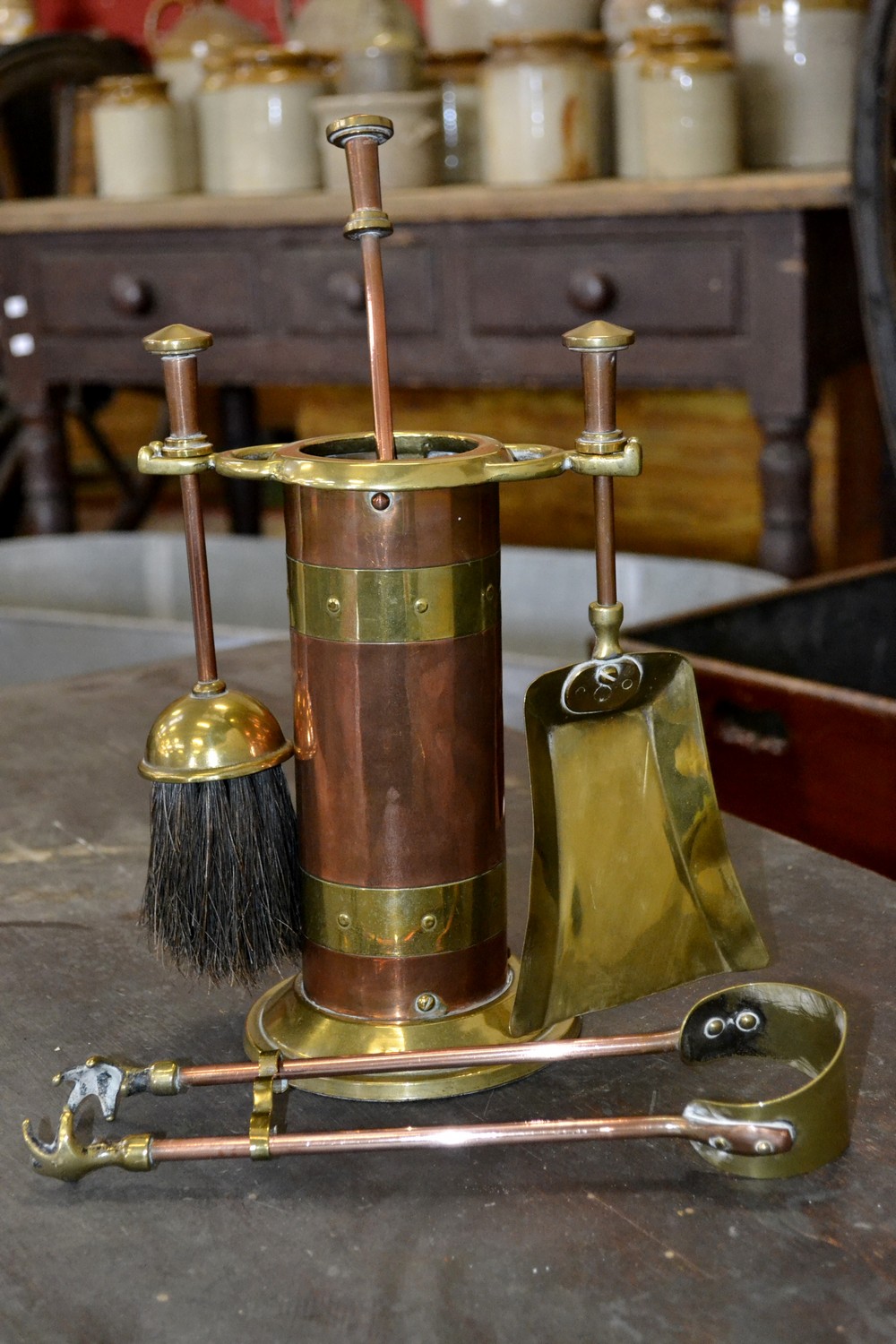 A copper and brass fireside companion set