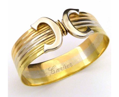 Tri-colour bangle with reversed C terminals, stamped 750 on the band and 375 on the clasp, gross weight 29.5g