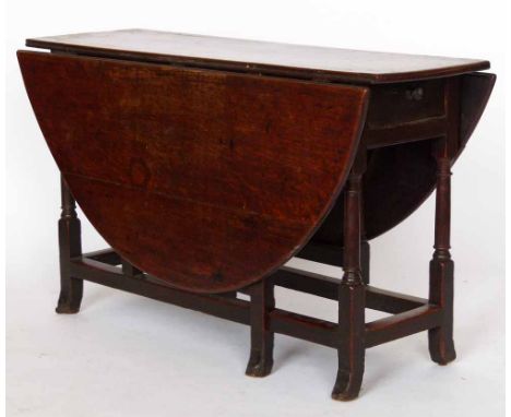 Oak gate-leg table circa 1700, the oval top over a single end drawer on block and turned legs and perimeter stretches, length