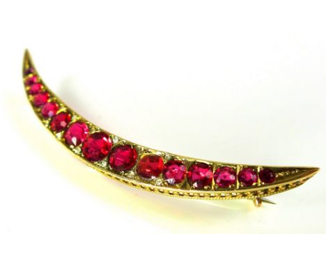 An Edwardian 9ct gold, ruby and diamond crescent brooch, set with fifteen rubies of graduating size interspersed with diamond
