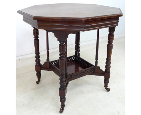 A late Victorian mahogany centre table, the octagonal surface raised on ring turned legs and slender support columns united b