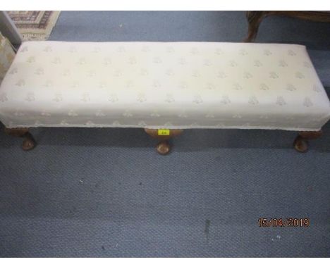 A walnut framed double foot stool with six cabriole legs having a cream upholstery depicting bees 