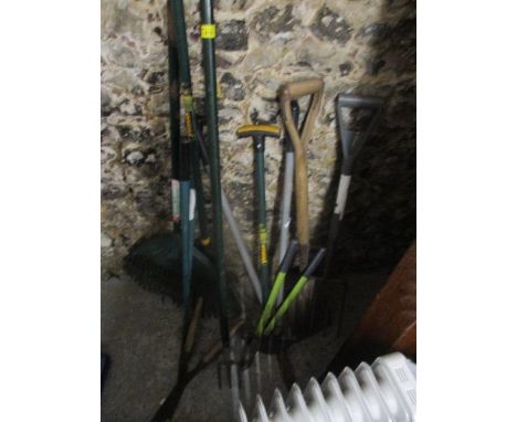 A selection of garden tools to include a spade, a rake and others 