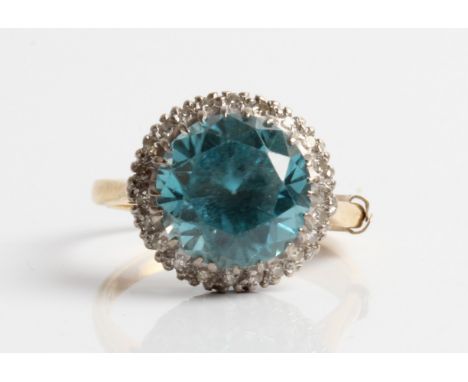 A blue zircon and diamond cluster ring, set with a central round cut blue zircon, measuring approx. 10mm, surrounded by a bor