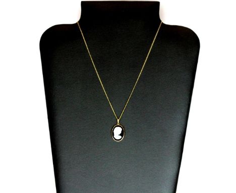 An unusual 9ct gold mounted opal and onyx cameo on a 9ct gold chain