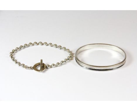 A silver bangle and a silver bracelet.