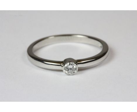 A Platinum and solitaire diamond in a rub over setting (K)