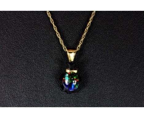 A 9ct gold mounted opal and onyx tortoise on a 9ct gold chain