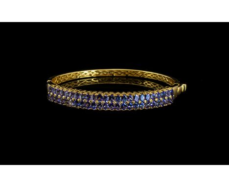 Tanzanite Double Row Hinged Bangle, two rows of oval cut tanzanites, totalling 9cts, set vertically across the front of the b