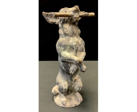 An early 20th century cast lead model of a Terrier Dog, standing on its hind legs, holding a stick in its mouth, 39cm high 