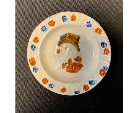 An early 19th century commemorative pearlware nursery plate, in relief with portrait of Queen Caroline, the rim with foliage,