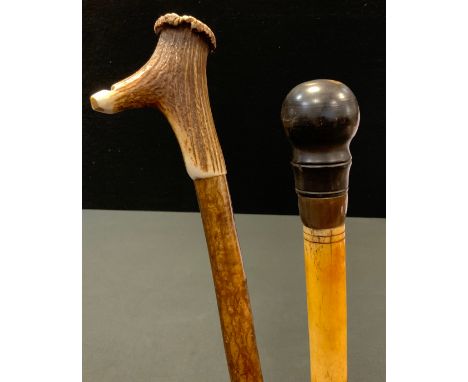 A Victorian bone walking stick, turned pommel, 83cm long, c.1890;  another, horn handle, with whistle, 95cm long (2) 