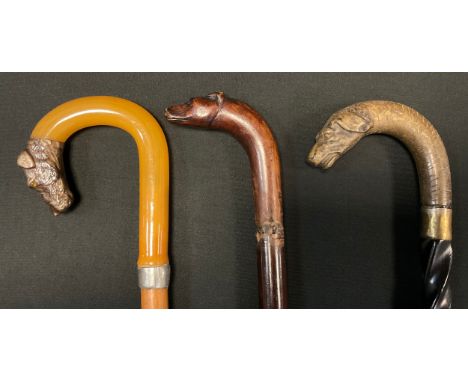 An early 20th century dogs head walking stick,  carved handle as a snarling hound, spiralled shaft, 86.5cm long;  others 89cm