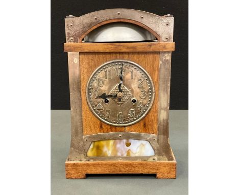 An Arts and Crafts oak and brass mounted mantel clock,  for Liberty &amp; Co, 14cm dial cast with Arabic numerals,  the arche