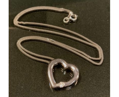 An 18ct white gold diamond heart pendant necklace, the open heart pendant set with a single round brilliant cut diamond appro