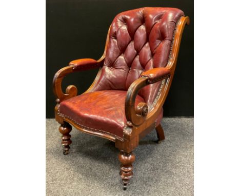 An early Victorian, button-back, leather library chair, scroll arms, padded leather elbow rests, serpentine front seat, turne