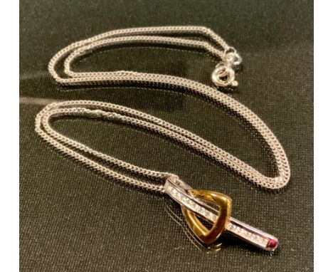 A diamond two tone yellow and white gold buckle pendant, set with fourteen round brilliant cut diamonds, total estimated diam