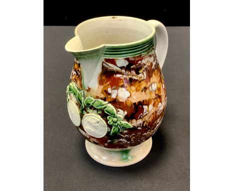 An 18th century Admiral Rodney slipware jug, applied with leafy swag and two roundels, with portrait and inscribed The hero w