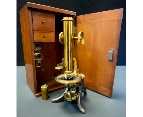 A late 19th/early 20th century lacquered brass and cast iron monocular microscope, rack-and-pinion adjustment, plano/convex m