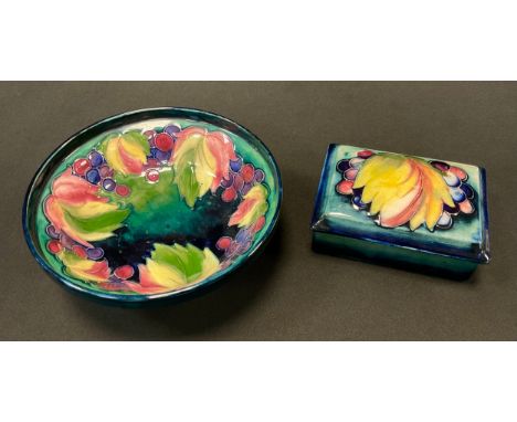 A Moorcroft Leaf and Berry bowl, tube lined with foliage in ones of red, yellow and green, on a mottled blue and green ground