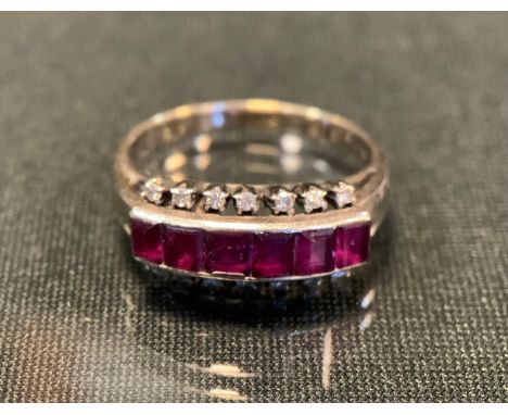 A ruby and diamond ring, set with six pinky red baguette cut rubies, between sixteen individually mounted round brilliant cut