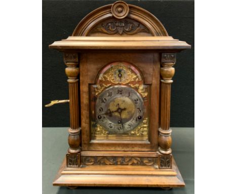 A late 19th century mahogany carved bracket clock, arched topped architectural case, gilt silvered dial, Arabic numerals, scr