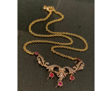 An Edwardian diamond and ruby necklace, the scrolling floral body set with five vibrant red rubies and thirty one rose cut di