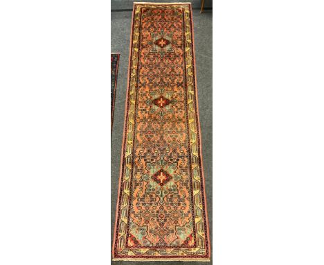 A Rudbar Runner carpet, hand knotted in soft tones of red, pink, cream, and blue, with a row of three medallions in a field o