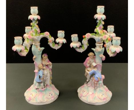 A pair of German four-light three branch figural candelabra, encrusted with flowers, the columns with mother and father with 
