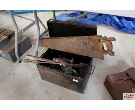 A metal box containing various saws, blow lamps and other tools