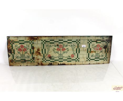 An enamel splash back having floral decoration, approx. 12" x 42"