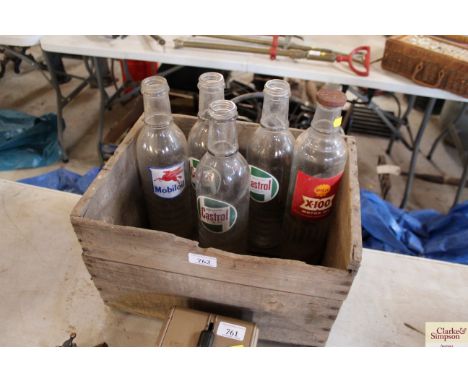 A wooden box containing five Castrol / Mobil Oil / Shell oil bottles