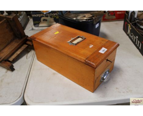 A vintage wooden cash till with key and drawer below