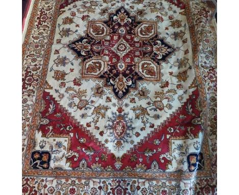 A Heriz style carpet, with central geometric medallion, on a beige ground, contained by geometric border, 230 x 160cm 
