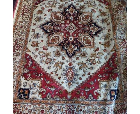 A Heriz style carpet, with central geometric medallion, on a beige ground, contained by geometric border, 230 x 160cm 