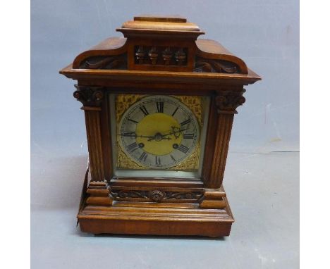 An early 20th century mahogany mantle clock, with Corinthian columns, raised on bun feet 