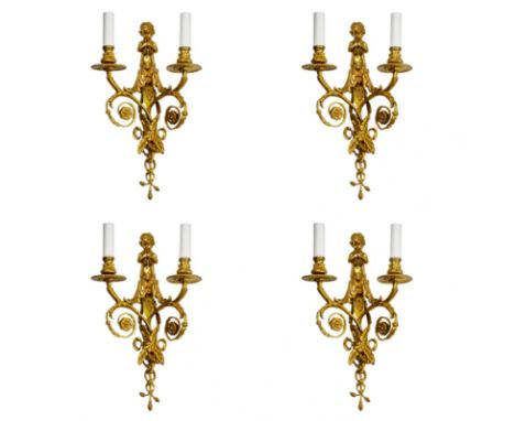 Four intricate gilded sconces with currency curls topped with trumpeting cherubs. Effectively postulate the style of Louis XV