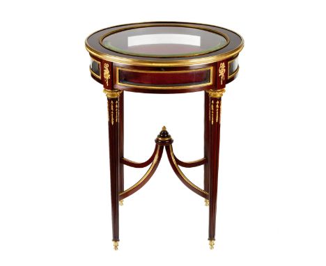 Round showcase-table mahogany with gilded bronze, neoclassical style. With beveled glass and graceful hipped legs. The inside